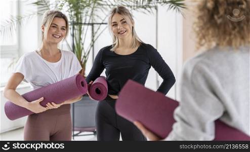 smiley women with yoga mats