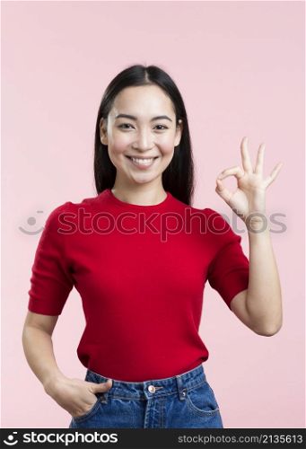 smiley young woman showing ok sign