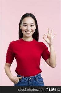 smiley young woman showing ok sign
