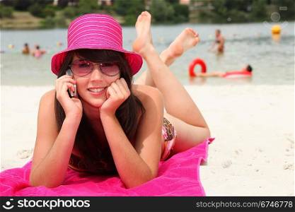 smiling 20 years old Asian girl relaxing on the beach and calling