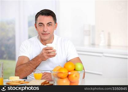 Smiling adult man having breakfast