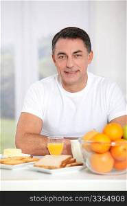 Smiling adult man having breakfast
