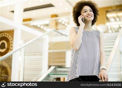 Smiling african american busi≠sswoman using mobi≤pho≠in office