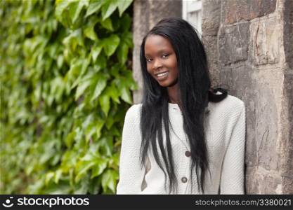 Smiling African American female standing in front of stone wall