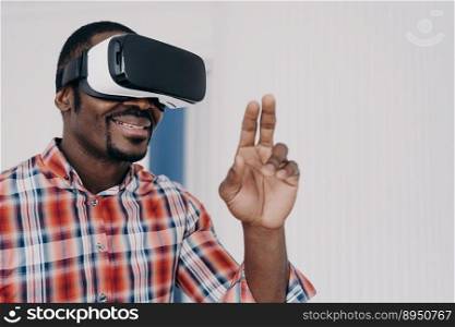 Smiling african american man using virtual reality glasses touch objects, interact with cyberspace, happy black guy in VR goggles playing online video game. Technology, entertainment.. African american man in virtual reality glasses, interact with cyberspace, play online video game