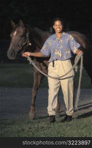 Smiling African American Woman Walking A Horse