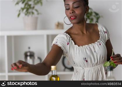 Smiling african woman chopping vegetables for salad at kitchen