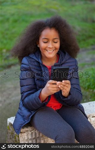 Smiling afro child with a mobile in the park taking a photo himself
