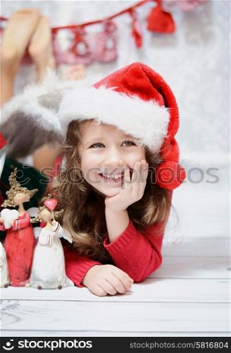 Smiling and cute girl in a Santa hat