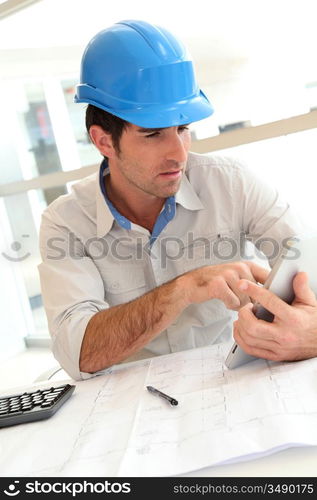 Smiling architect in office working with electronic tablet