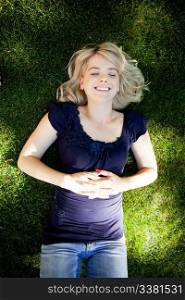 Smiling attractive student laying on grass