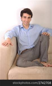 smiling attractive young man sitting on the couch