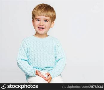 Smiling baby boy in blue pullover