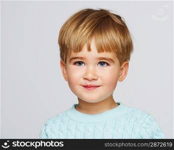 Smiling baby boy in blue pullover portrait