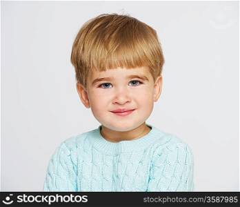 Smiling baby boy in blue pullover portrait