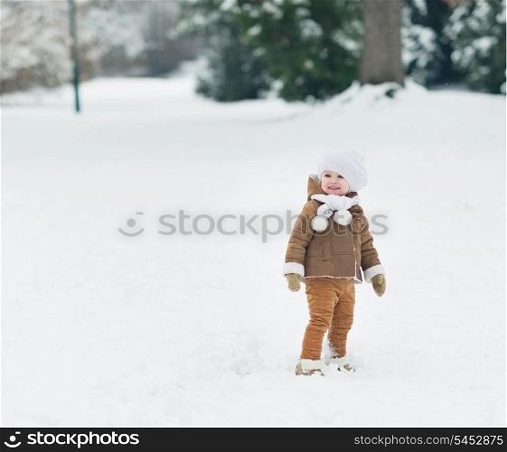 Smiling baby walking in winter park