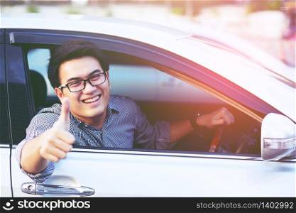 Smiling beautiful man driving her car