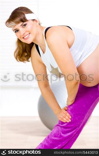 Smiling beautiful pregnant woman doing stretching exercises &#xA;