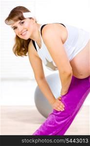 Smiling beautiful pregnant woman doing stretching exercises &#xA;
