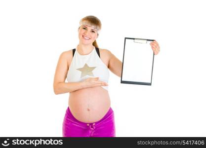 Smiling beautiful pregnant woman pointing on blank clipboard isolated on white&#xA;