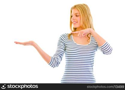 Smiling beautiful teen girl pointing finger on empty hand isolated on white&#xA;