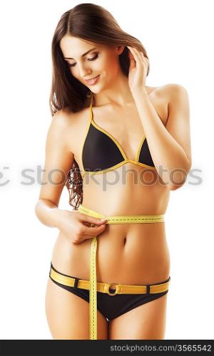 smiling beautiful woman in swimsuit looking at measure on white background
