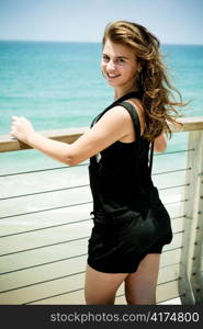 Smiling beauty standing on the deck and looking at camera