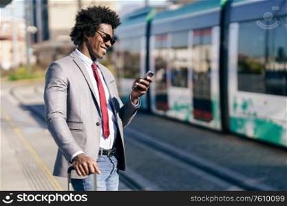Smiling Black Businessman waiting for the next train. Man with afro hair commuting.. Smiling Black Businessman waiting for the next train
