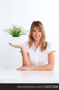 Smiling blond woman holding flowerpot