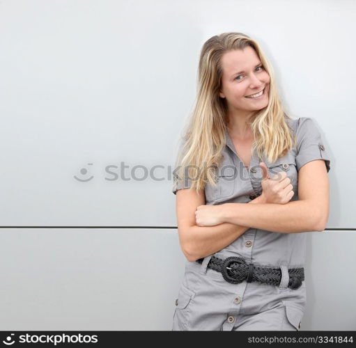 Smiling blond woman on grey background