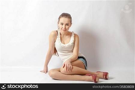 Smiling blond woman shirt and jeans shorts sitting