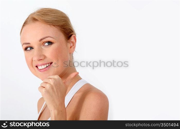 Smiling blond woman showing thumb up on white background