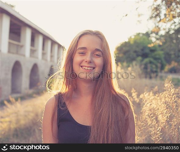 smiling blond women at autumn sunset. Backlit. Long blond hair. Cute pretty young lady outdoors rejoice of warm weather fall