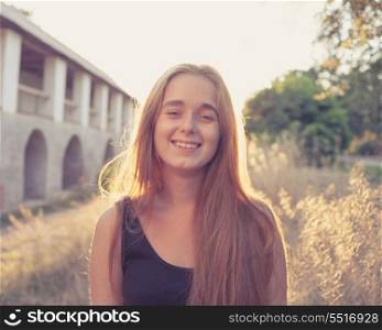smiling blond women at autumn sunset. Backlit. Long blond hair. Cute pretty young lady outdoors rejoice of warm weather fall