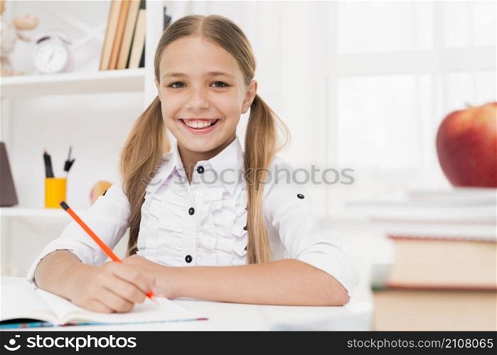 smiling blonde elementary school girl doing homework