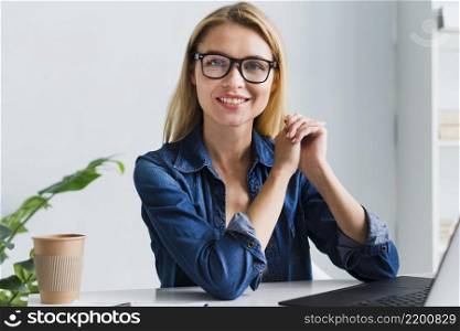 smiling blonde employee with glasses looking camera