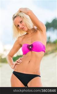 smiling blonde in a bikini on a sandy beach
