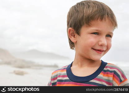 Smiling boy (5-6) on beach