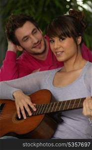 Smiling boy and girl playing guitar