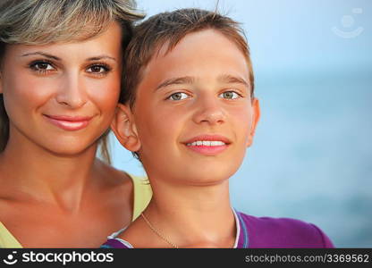 smiling boy and young woman on beach in evening