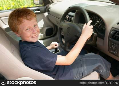 Smiling boy at wheel of car