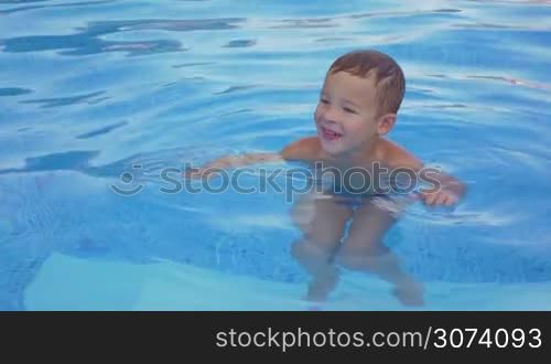 Smiling boy is resting in the swimming pool