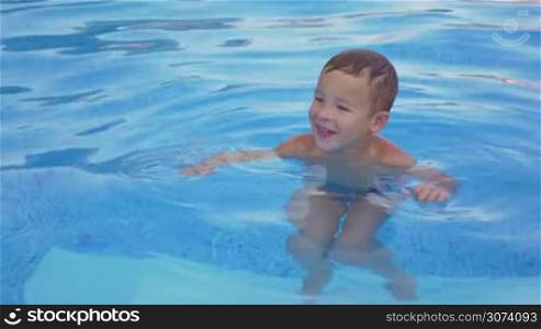 Smiling boy is resting in the swimming pool
