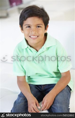 Smiling Boy Sitting On Sofa