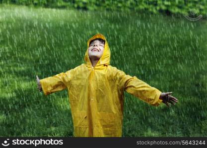Smiling boy wearing raincoat in park