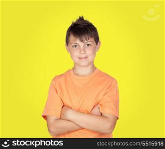 Smiling boy with arms crossed on yellow background