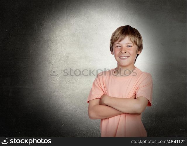 Smiling boy with arms crossed with a gray background