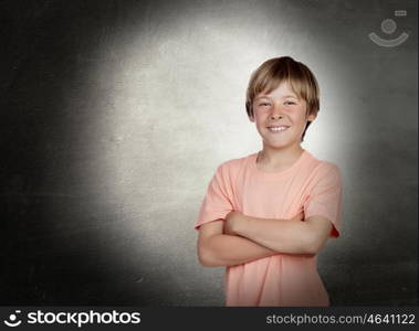Smiling boy with arms crossed with a gray background