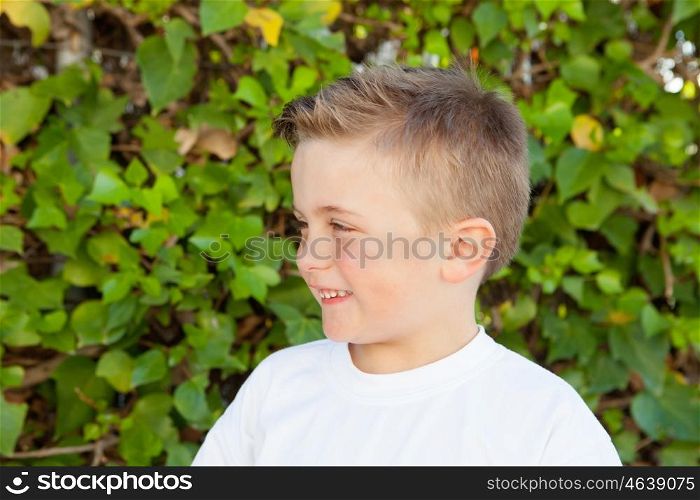 Smiling boy with blue eyes about 5 years in the garden