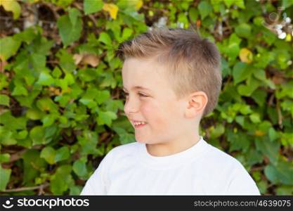 Smiling boy with blue eyes about 5 years in the garden